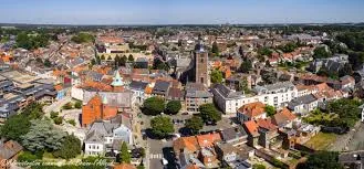 Scène urbaine de Braine-l'Alleud avec artisan plombier local devant l'église Saint-Étienne, prêt à intervenir.