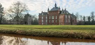 Scène urbaine de Grâce-Hollogne avec un plombier au travail devant un bâtiment typique en briques rouges.