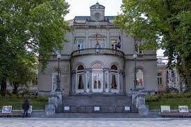 Plombier Ixelles camion garé près de l'ancienne église Saint-Boniface rue animée avec façades Art Nouveau typiques.