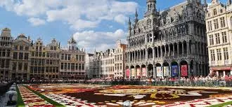 Débouchage Mouscron rue animée avec façades en briques, signalisation locale et véhicules garés devant les commerces.