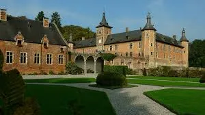 Plombier Rixensart réparant une fuite près du Château de Rixensart entouré de verdure et vieux bâtiments charmants