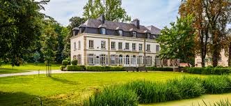 Plombier Uccle travaillant près de l'église Saint-Job, rue pavée avec des maisons typiques et arbres verdoyants.